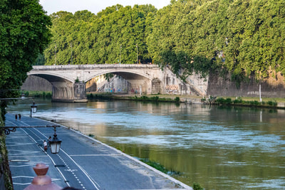 The Tiber is a river like all rivers except that it is in Rome, famous in its own right, has fifty foot walls, wide asphalt path on the west bank, many famous bridges over it, and is the eternal in the city of Rome.